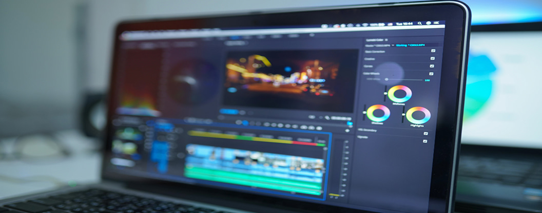 ノートPCの画面に映し出された動画編集ソフトの操作画面。カラーホイールやタイムライン、プレビューウィンドウが表示されており、クリエイティブな制作やカラーグレーディング作業の工程を伝えています。
