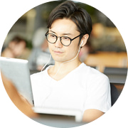 メガネを着用し、タブレット端末を真剣に見つめて操作する日本人男性
